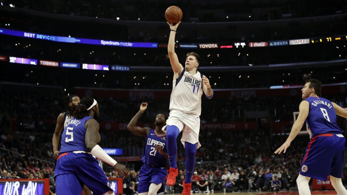 Dallas Mavericks' Luka Doncic (77) puts up a running floater against the Clippers.