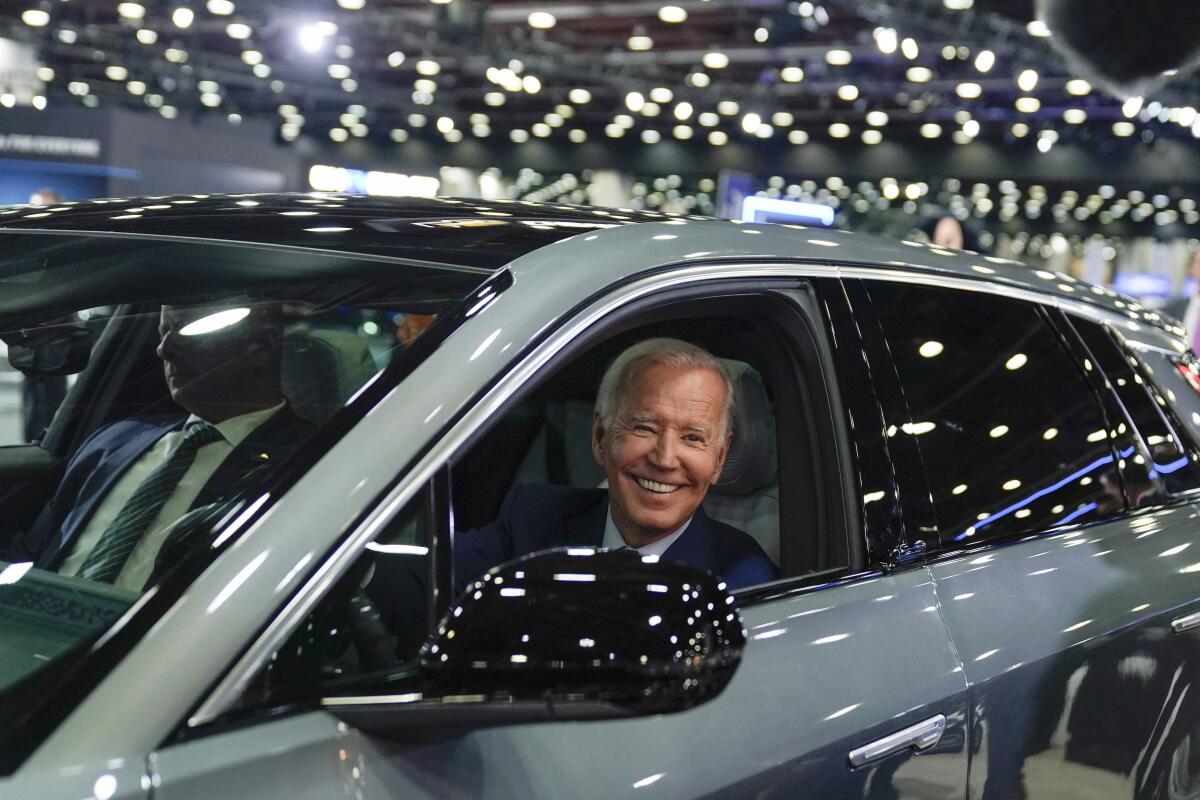 ARCHIVO - El presidente Joe Biden conduce un Cadillac Lyriq por la sala de exhibición 