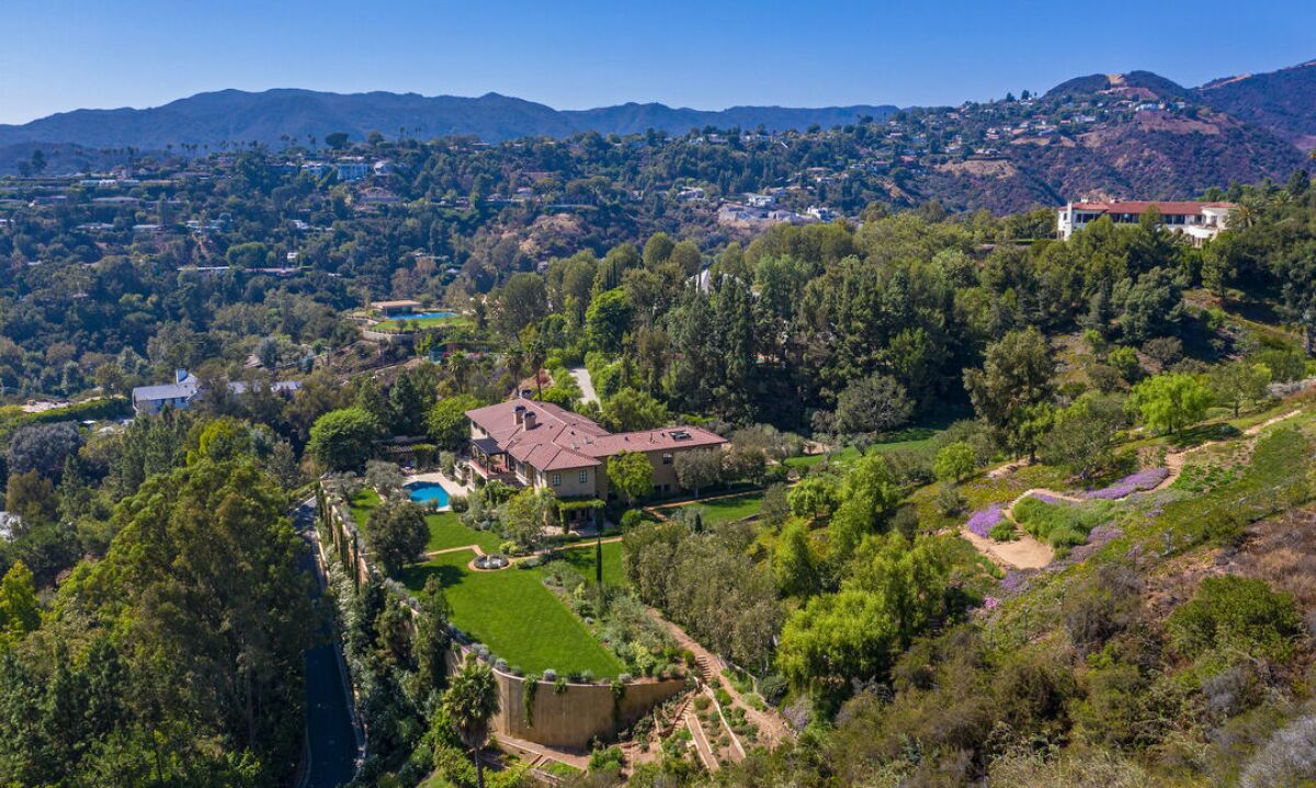 Aerial view of the six-acre compound with a Mediterranean mansion and pool surrounded by trees and hills
