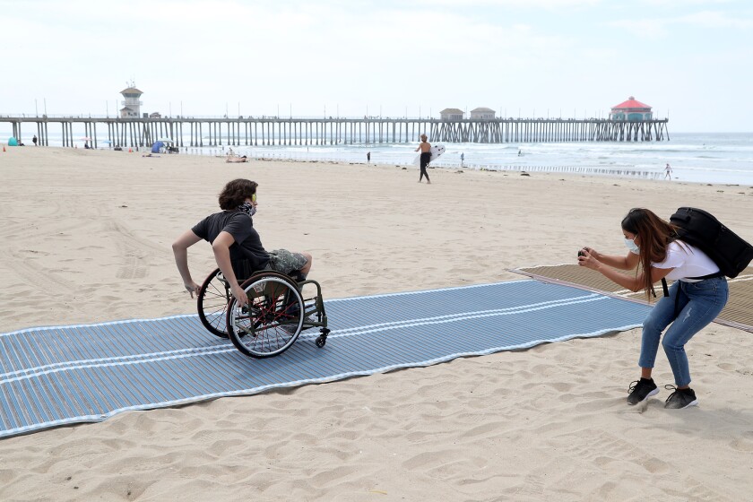 Adaptive surfer Kumaka Jensen, 14, of Huntington Beach takes place on the first Mobi-Mat in Huntington Beach in May.
