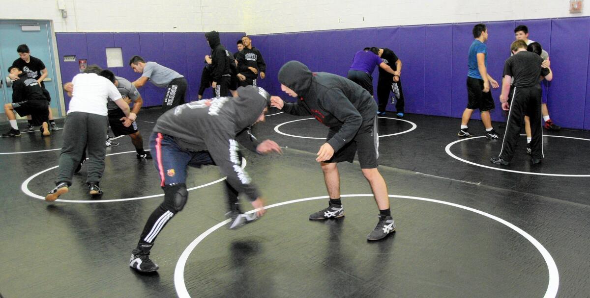 Members of the Hoover High School wrestling team learn taken-down moves during practice at the school's gym in Glendale on Friday, Nov. 20, 2015.