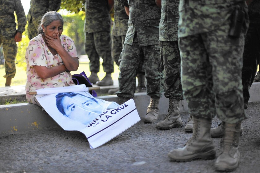 A woman sits with a picture of her son during a protest in December by the families of 43 college students who disappeared last year in Iguala, Mexico.