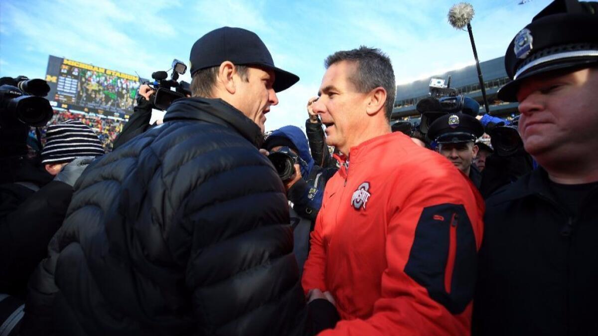 Michigan Coach Jim Harbaugh and Ohio State Coach Urban Meyer meet on the field following the Buckeyes' win over the Wolverines, 42-13, last season.