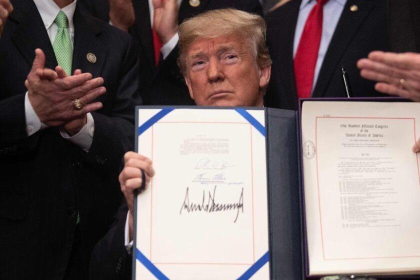 US President Donald Trump shows the Economic Growth, Regulatory Relief, and Consumer Protection Act after signing it in the Roosevelt Room at the White House in Washington, DC, on May 24, 2018. / AFP PHOTO / NICHOLAS KAMMNICHOLAS KAMM/AFP/Getty Images ** OUTS - ELSENT, FPG, CM - OUTS * NM, PH, VA if sourced by CT, LA or MoD **