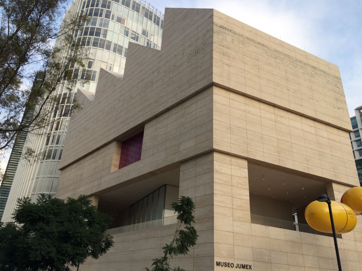 A view of the Museo Jumex from below shows the museum's serrated roofline and its travertine facade.