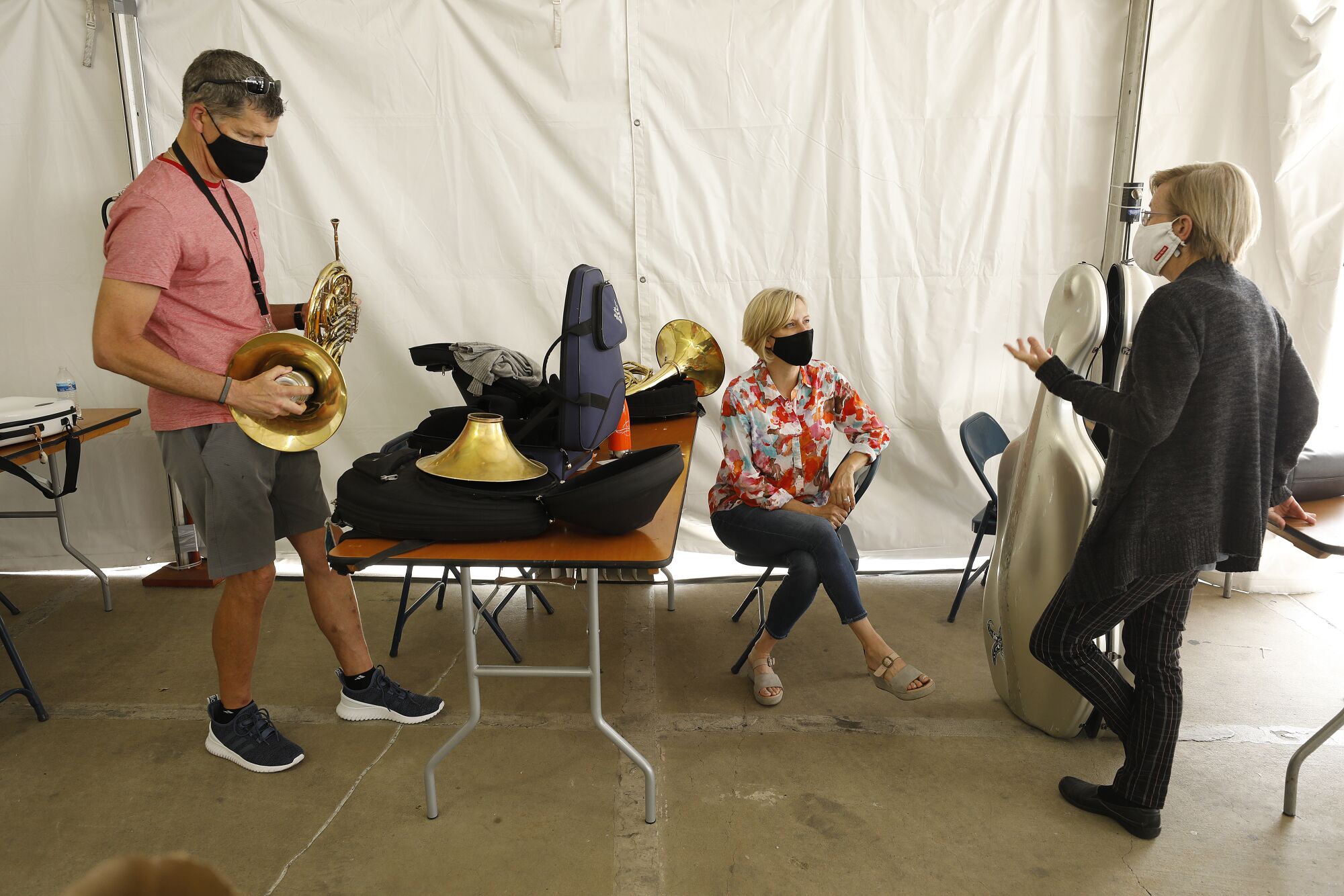 Musicians in masks converse among their instruments