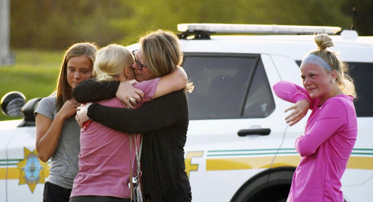 People console each other after a shooting at Cornerstone Church on Thursday, June 2, 2022 in Ames, Iowa. Two people and a shooter died Thursday night in a shooting outside a church in Ames, authorities said. (Nirmalendu Majumdar/The Des Moines Register via AP)