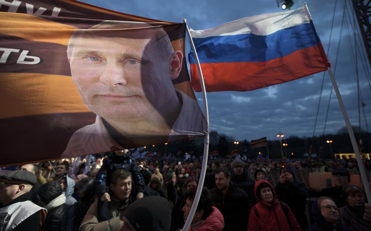 A flag with a portrait of Vladimir Putin waves over a crowd commemorating Russia's 3-year-old annexation of the Crimea in Ukraine -- a component of Russia's attempts to maintain its historical influence.
