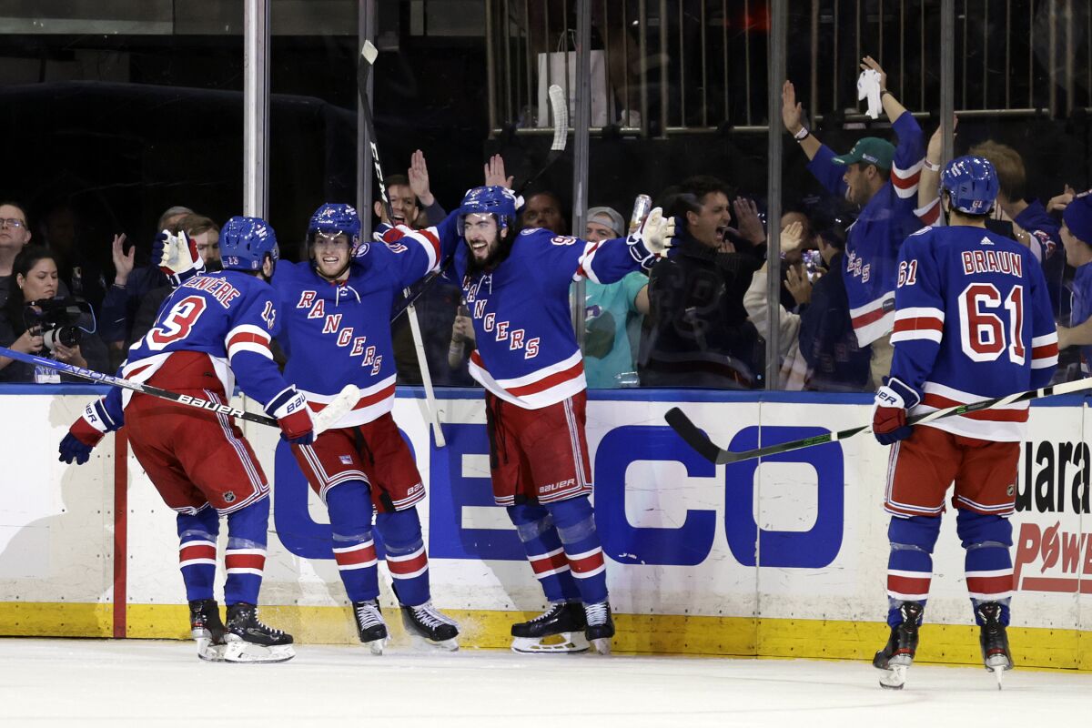 New York Rangers center Mika Zibanejad (93) celebrates with teammates after scoring a goal against the Pittsburgh Penguins during the third period in Game 7 of an NHL hockey Stanley Cup first-round playoff series Sunday, May 15, 2022, in New York. (AP Photo/Adam Hunger)
