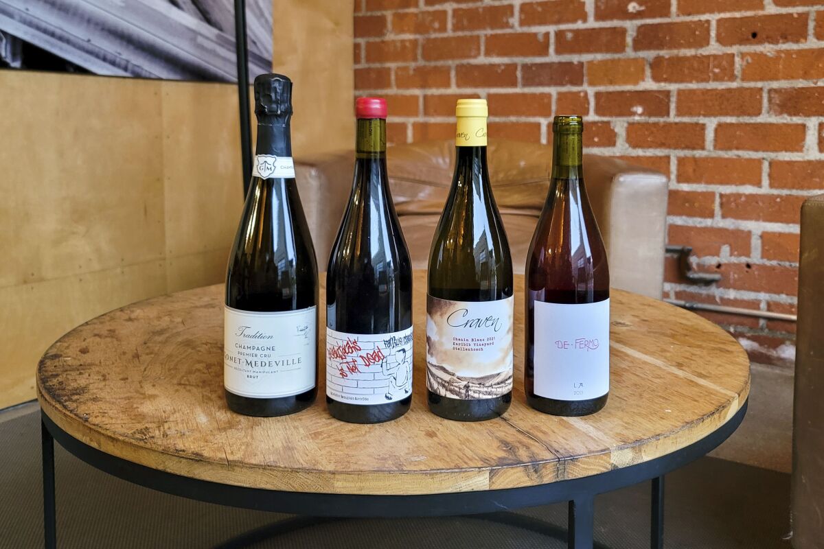 Four bottles of wine on a wood-topped table