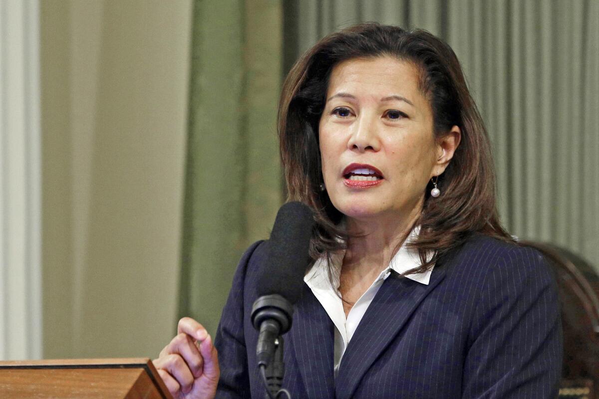 A woman gestures while speaking into a microphone