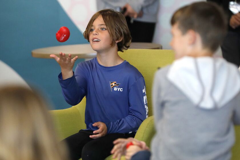 A youngster plays catch with a toy kidney he won while listening to educational event by Fresenius Kidney Care volunteers at the Boys & Girls Club of Costa Mesa on Wednesday. The event focused on helping kids prevent kidney disease by making health lifestyle decisions throughout their lives.