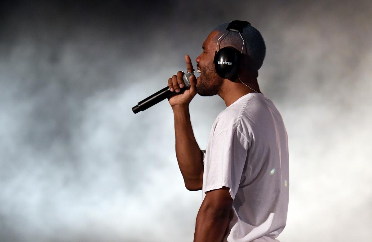 Frank Ocean performing onstage wearing headphones.