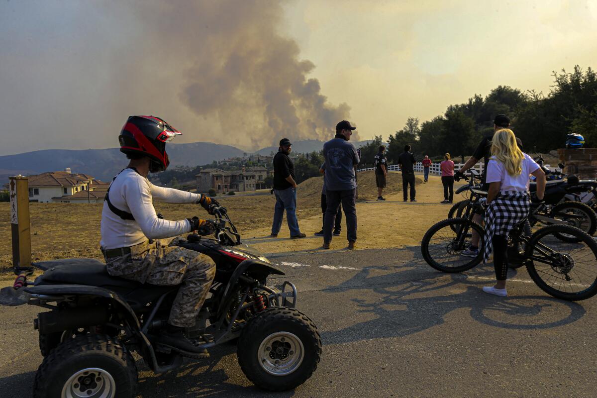 Residents watch the Blue Ridge fire from Vellano Club Drive on Tuesday in Chino Hills.