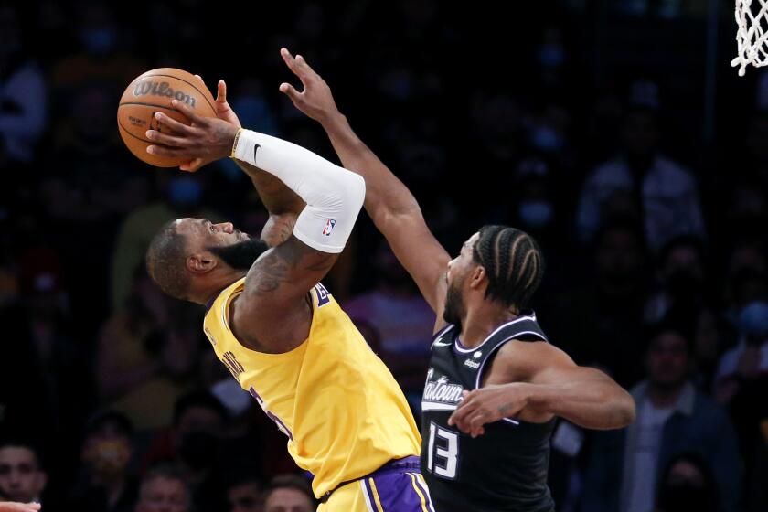 Los Angeles Lakers forward LeBron James, left, shoots against Sacramento Kings forward Tristan Thompson during the second half of an NBA basketball game in Los Angeles, Friday, Nov. 26, 2021. The Kings won 141-137 in triple overtime. (AP Photo/Ringo H.W. Chiu)