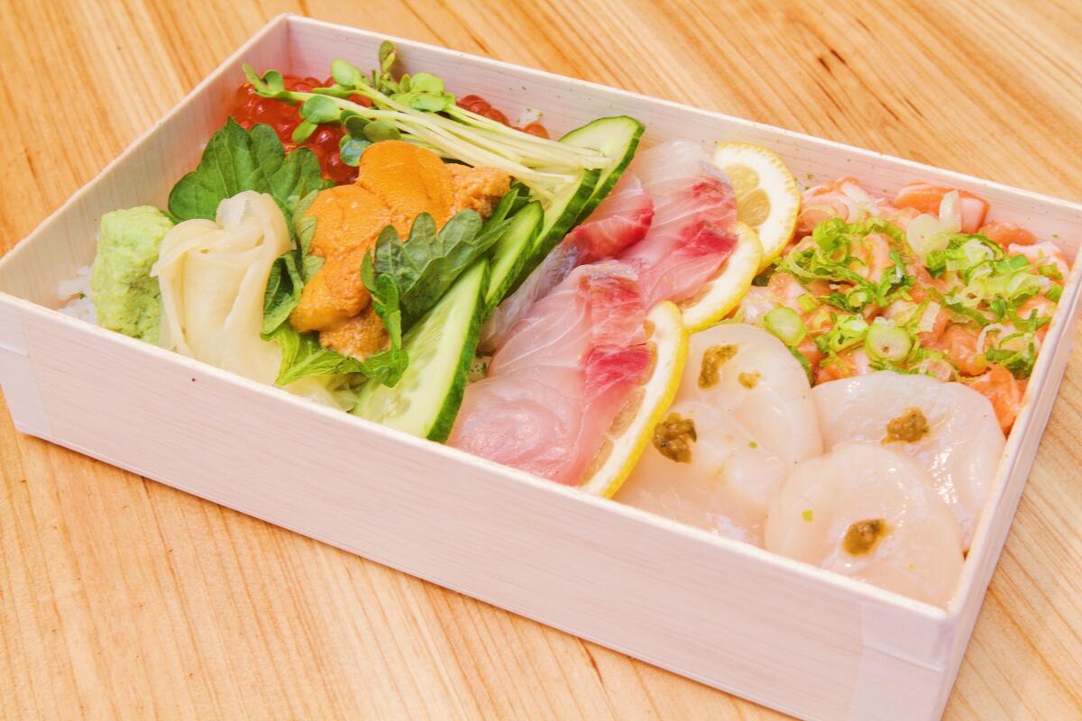 Raw fish and vegetables in a white box prepared by Yojimbo.