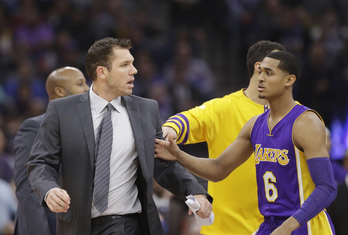 Lakers guard Jordan Clarkson (6) tries to guide Coach Luke Walton, left, to the locker room after he was ejected during the first quarter on Monday.