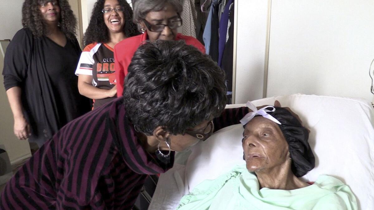 Lessie Brown is visited by her daughters, Verline Wilson, foreground, and Vivian Hatcher, third from left, and other family and friends at her home in Cleveland Heights, Ohio, on Sept. 22, 2018. Brown, believed to be the oldest person in the United States, died Tuesday.