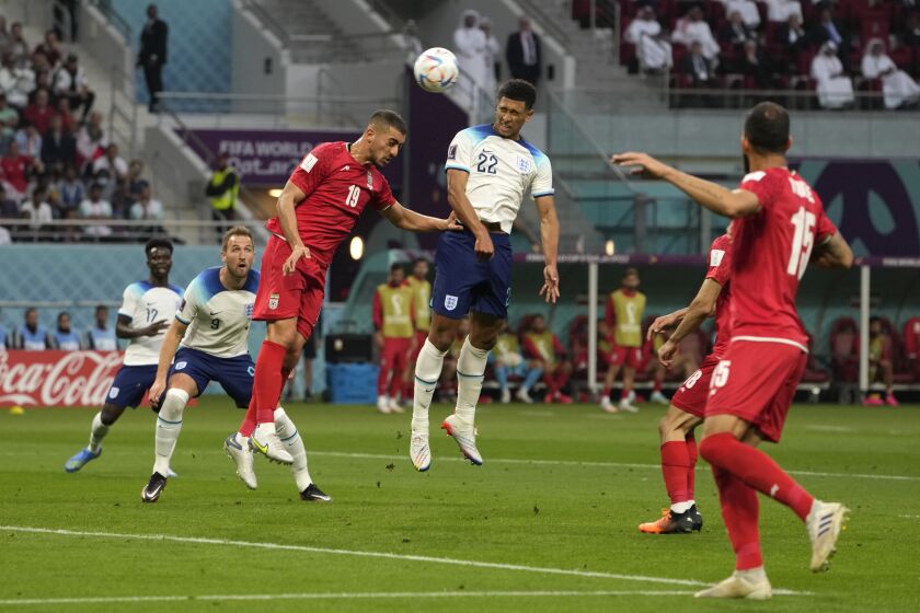 England's Jude Bellingham, centre, scores his side's opening goal during the World Cup group B soccer match between England and Iran at the Khalifa International Stadium in Doha, Qatar, Monday, Nov. 21, 2022. (AP Photo/Alessandra Tarantino)
