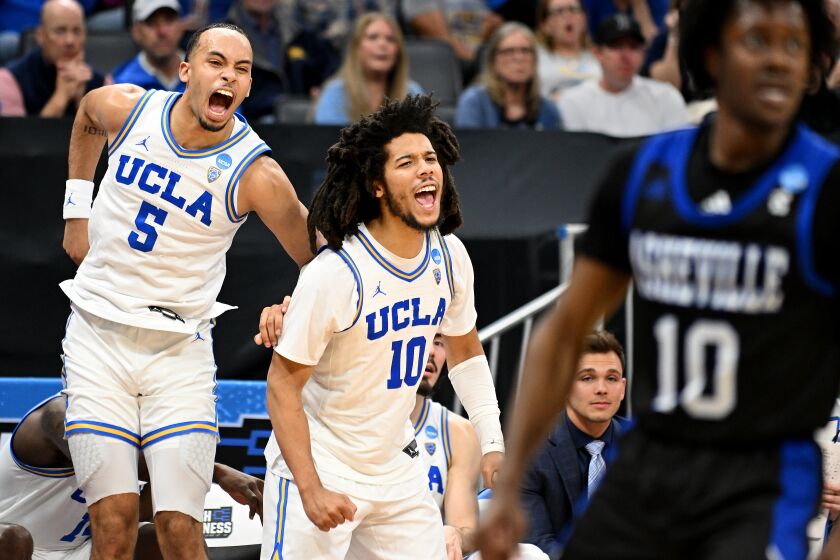 Sacramento California March 16, 2023-UCLA's Amari Bailey, left, and Tyger Campbell celebrate on the bench against UNC Asheville in the second half of the first round of the NCAA Tournament in Sacramento Thursday. (Wally Skalij/Los Angeles Times)