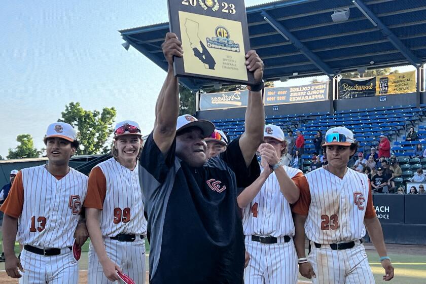 Coach Darrell Davis of Castaic raises the Division 6 championship plaque after his team's 7-0 win over Hesperia Christian.