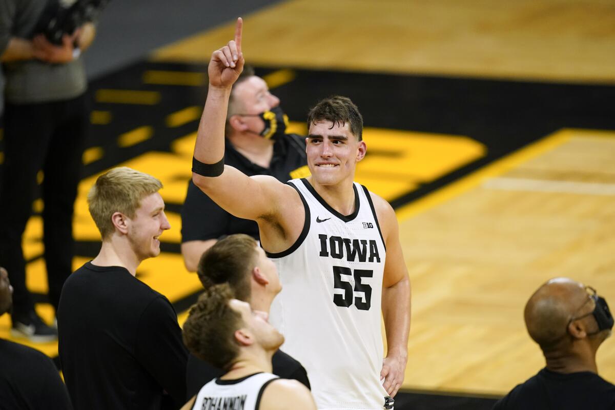 FILE - Iowa center Luka Garza (55) reacts during a video tribute following an NCAA college basketball game against Penn State in Iowa City, Iowa, in this Sunday, Feb. 21, 2021, file photo. Iowa’s Luka Garza is The Associated Press men’s basketball player of the year for the Atlantic Coast Conference and a member of The AP All-Big Ten first team announced Tuesday, March 9, 2021. (AP Photo/Charlie Neibergall, File)