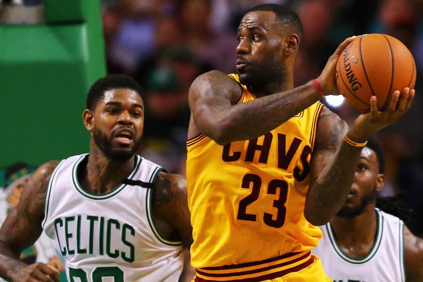 Boston's Amir Johnson defends Cleveland Cavaliers LeBron James during the third quarter on Tuesday.
