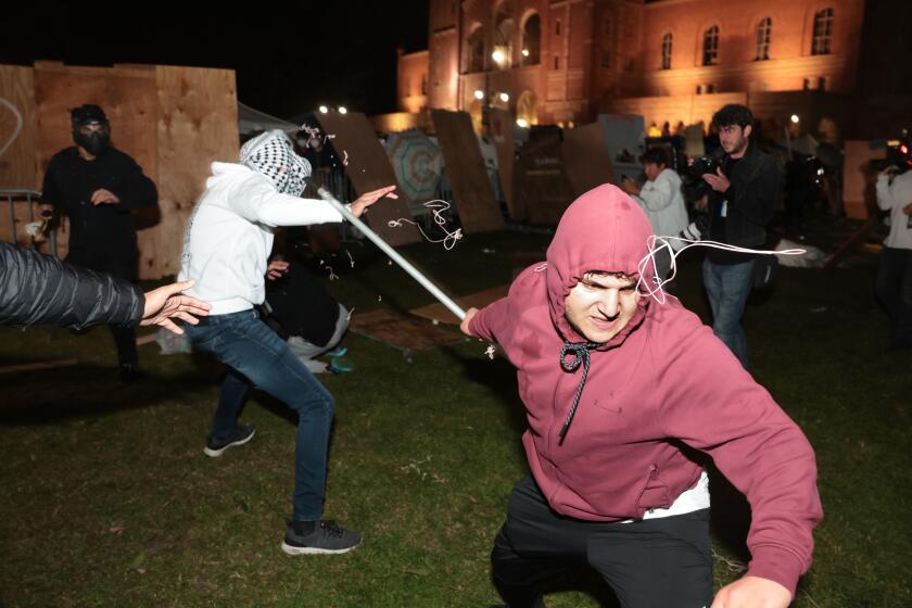 LOS ANGELES, CALIFORNIA - May 1: A Pro-Palestinian protestor clashes with a pro-Israeli supporter at an encampment at UCLA early Wednesday morning. (Wally Skalij/Los Angeles Times)