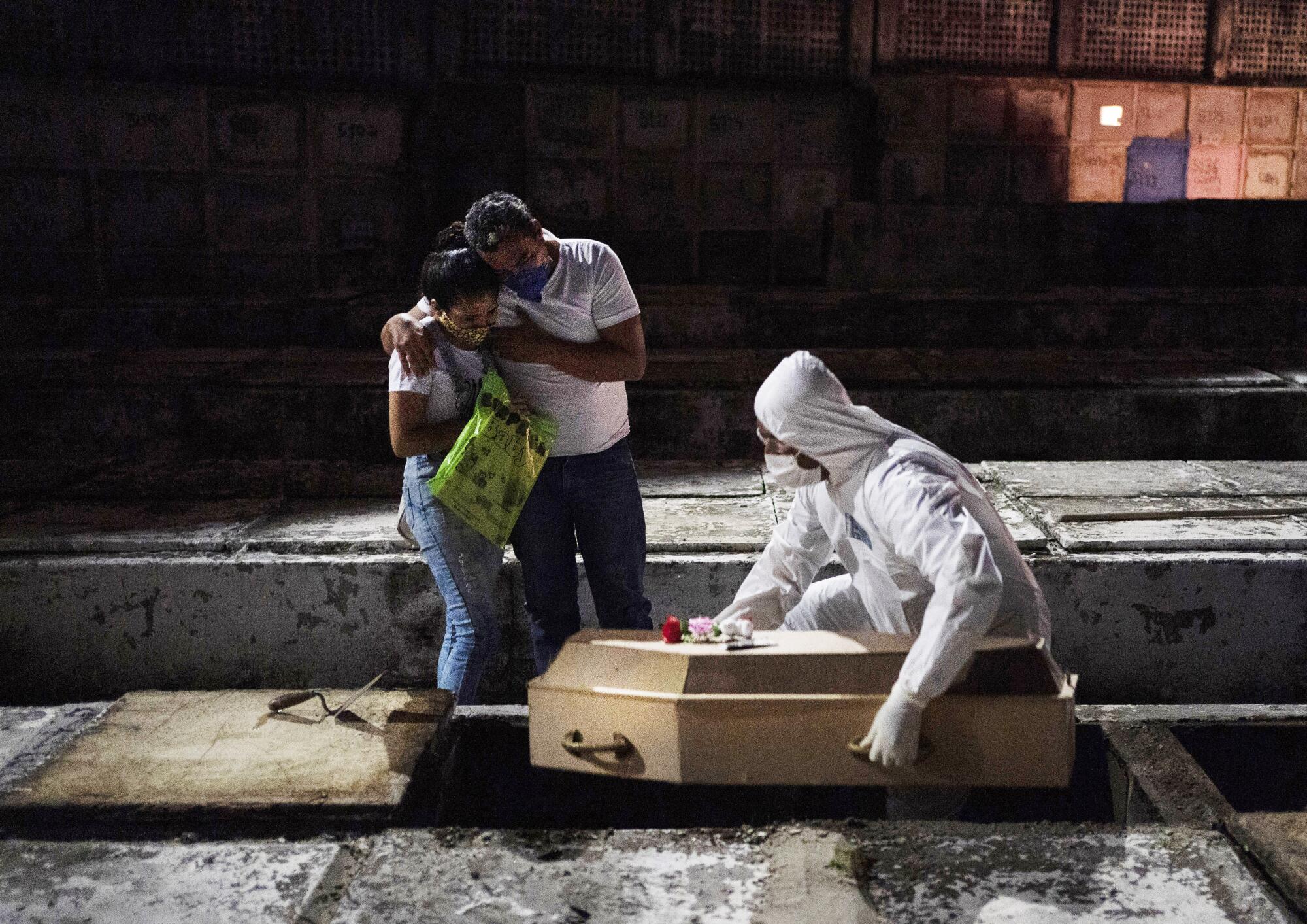 Andreia Silva de Sousa and her husband at the burial of their daughter.