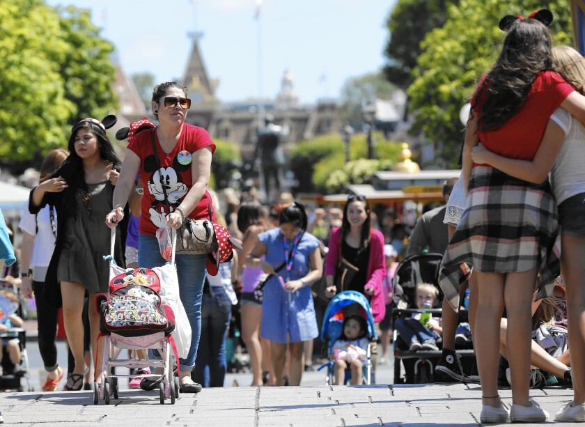 Walt Disney Co. is actively looking at “variable” pricing for Disneyland, a system in which prices would rise during periods of high demand. Above, parkgoers walk along Main Street in May 2014.