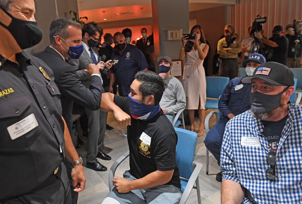 L.A. City Firefighter Andrew Tom greets L.A. Mayor Eric Garcetti at a reunion for injured firefighters 