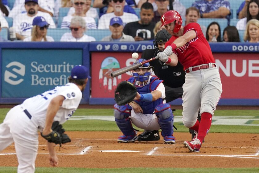 Philadelphia Phillies' Rhys Hoskins, right, hits a solo home run as Los Angeles Dodgers starting pitcher.