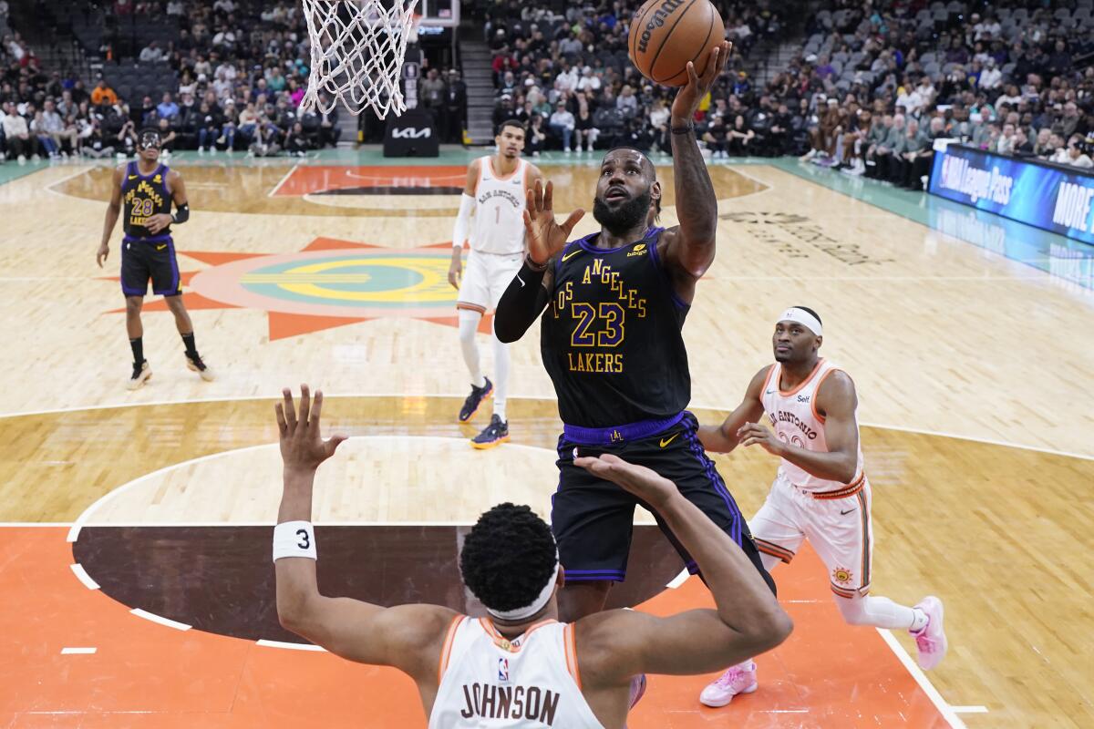 Lakers star LeBron James shoots over San Antonio Spurs forward Keldon Johnson during the first half.