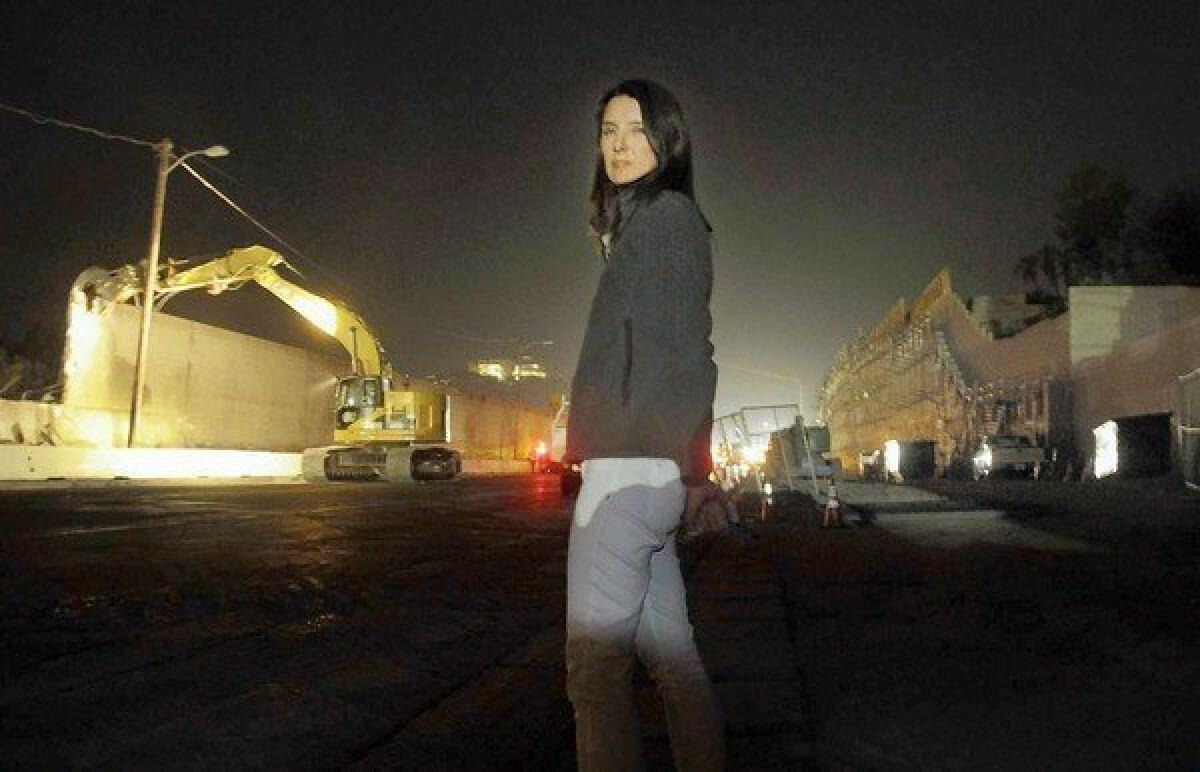 Kim Sandifer stands between her property wall on the right and a sound wall on the 405 Freeway on the left. Sandifer lives in Westwood Hills, ground zero of the massive construction project to add a 10-mile carpool lane to the 405 through the Sepulveda Pass.