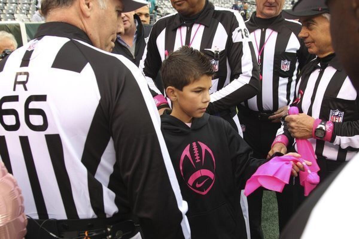 Dante Cano meets with game officials and gets a look at the pink penalty flags to be used in the Jets-Dolphins game today at MetLife Stadium.