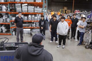 San Marcos, CA - May 10: High school seniors from San Marcos touring the warehouse of Action Air Conditioning, Heating & Solar during a visit there with the Promise 360 Program. Speaking to them in the foreground is company Production Director Casey McQuown. At left leading the tour is company General Manager Richard Johnson. (Charlie Neuman / For The San Diego Union-Tribune)