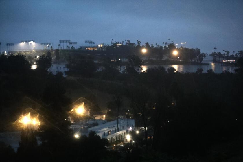 LOS ANGELES, CA - AUGUST 20, 2023 - Dodgers Stadium continues to glow above Elysian Park during Hurricane Hilary, now a tropical storm, in Los Angeles on August 20, 2023. (Genaro Molina / Los Angeles Times)