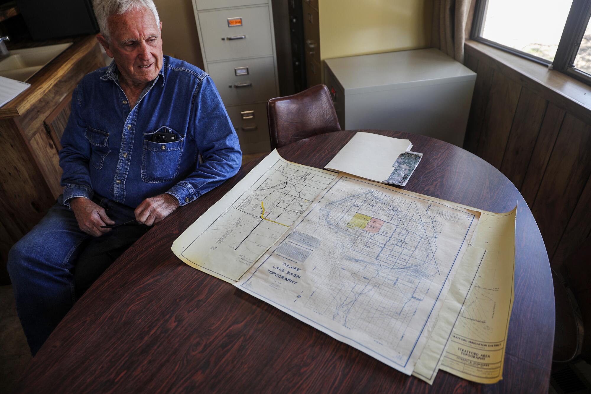Farmer Charlie Meyer sits in his office with a topographic map of the Tulare Lake Basin.