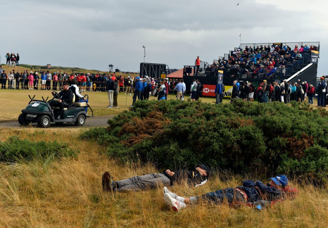 British Open spectators nap behind a clump of bushes at Carnoustie Golf Club in Carnoustie, Scotland.