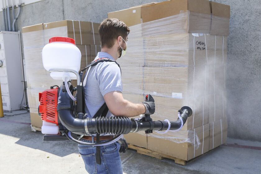 Using a sprayer called the Tomahawk Fogger, Jim Nora, national account sales manager at Tomahawk, sanitizes 2 pallets of merchandise delivered to the company's warehouse before unpacking them in Otay Mesa area on May 8, 2020 in San Diego, California.