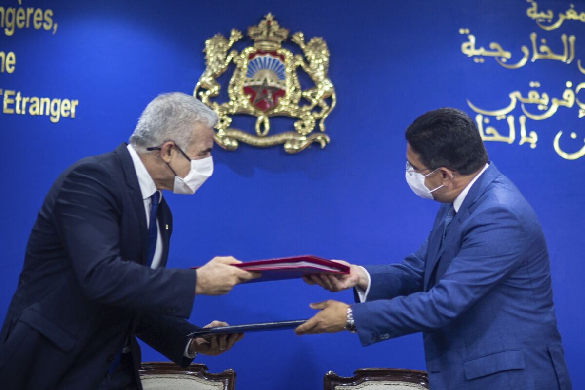 Moroccan Foreign Minister Nasser Bourita, right, and Israeli Foreign Minister Yair Lapid, left, exchange signed cooperation agreements between the two countries, in Rabat, Morocco, Wednesday, Aug. 11, 2021. The Israeli Foreign Minister Yair Lapid is on an official visit to Morocco. (AP Photo/Mosa'ab Elshamy)