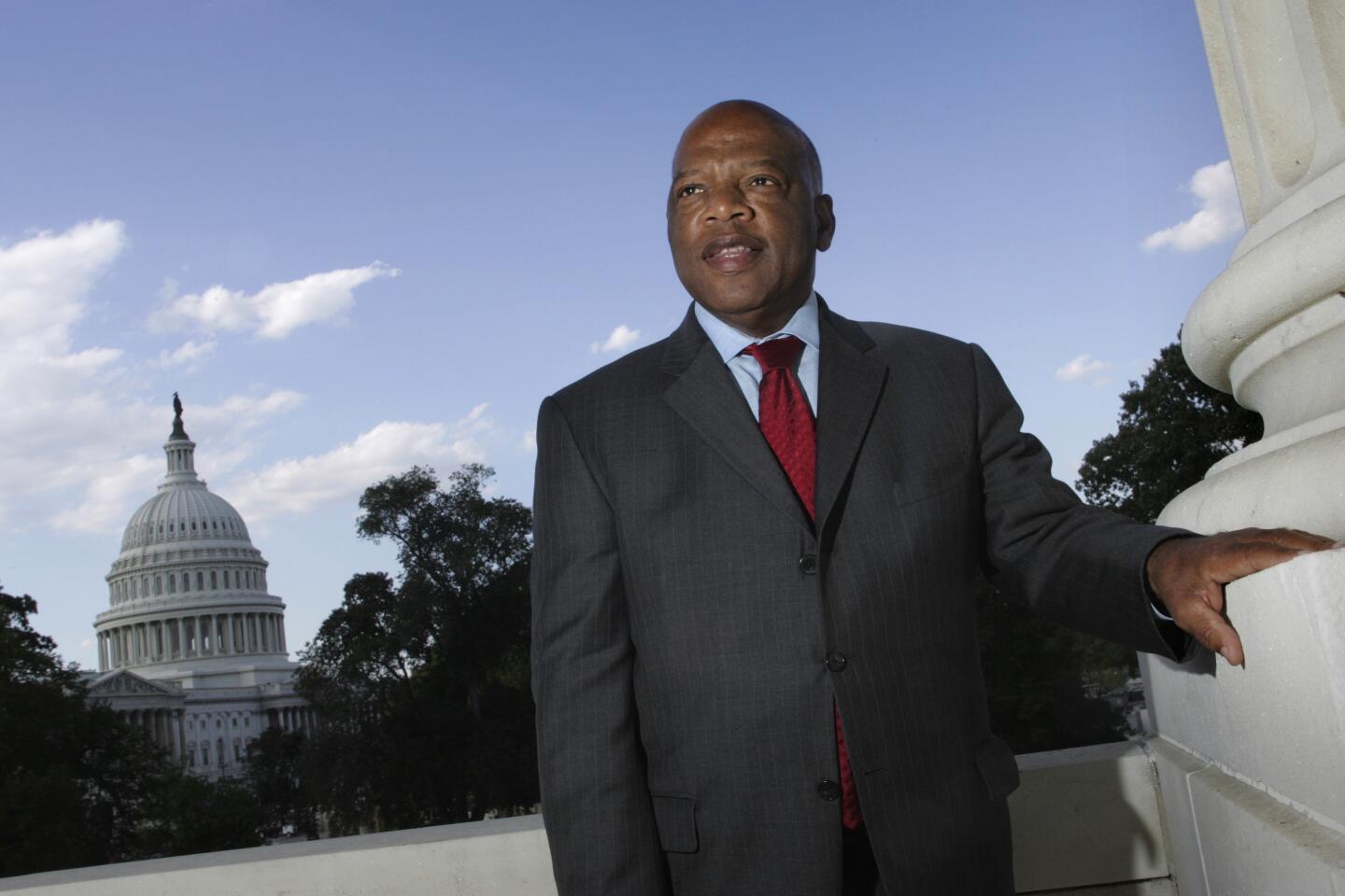 John Lewis is pictured standing in a suit with the Capitol Dome in the background