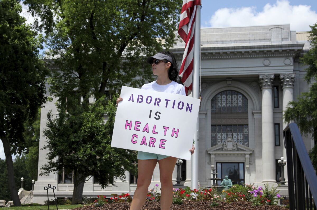 A protester holds a sign reading "Abortion Is Healthcare."