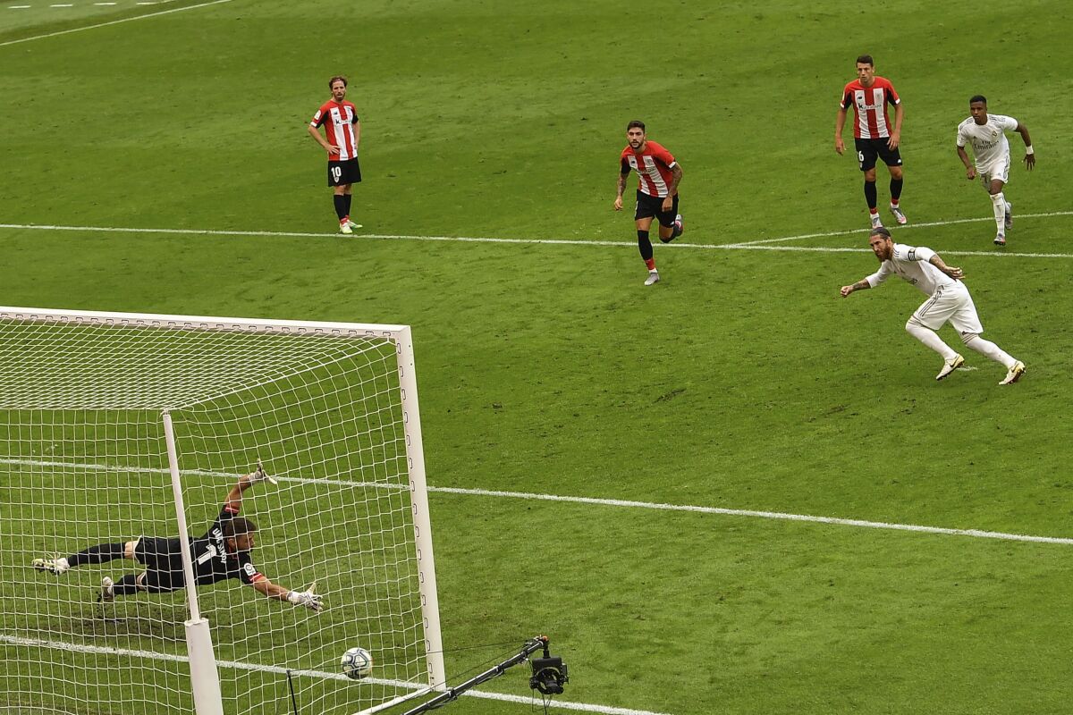 Real Madrid's Sergio Ramos, right, scores the opening goal from a penalty shoot during the Spanish La Liga soccer match between Athletic Club and Real Madrid at the San Manes stadium in Bilbao, Spain, Sunday, July 5, 2020. (AP Photo/Alvaro Barrientos)