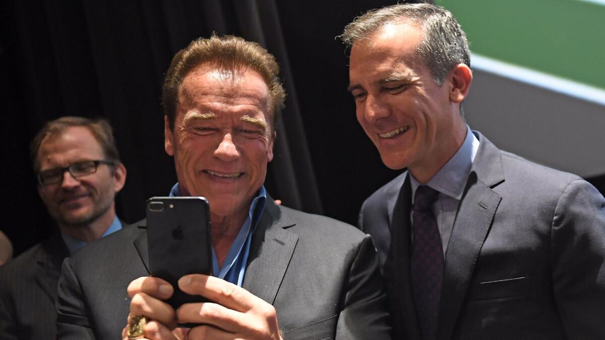 Mayor Eric Garcetti, left, and former Gov. Arnold Schwarzenegger chat after participating in a discussion on May 28 on climate change.