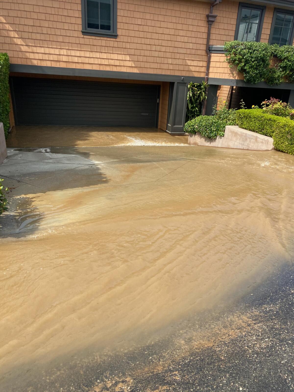 The driveway of the Senks' home was flooded after a water main owned by the city broke.