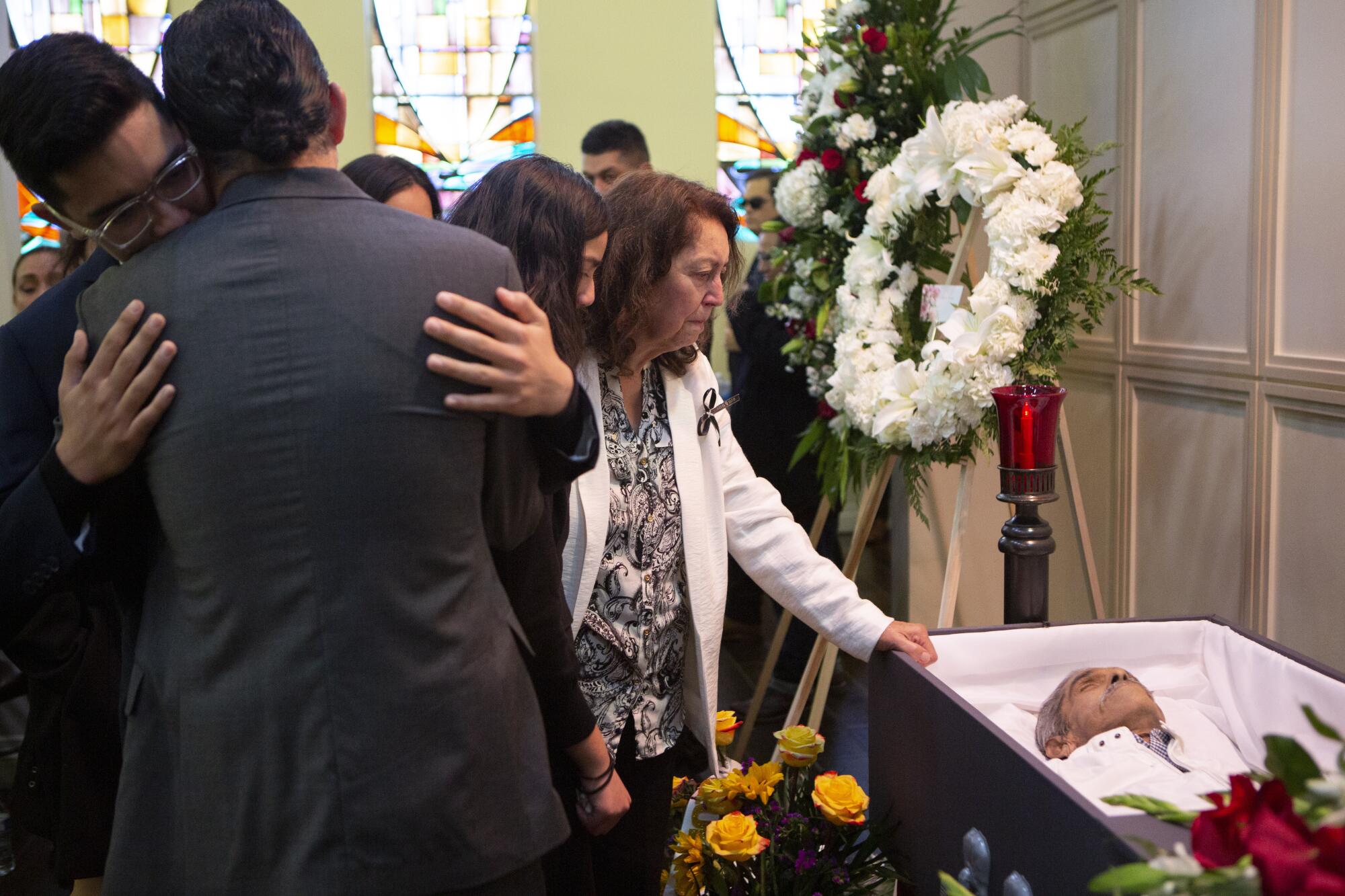 Rosario Tovar Barraza, al centro, ve el cuerpo de su esposo después de su rosario y servicio conmemorativo en la funeraria Guerra y Gutiérrez en Los Ángeles.