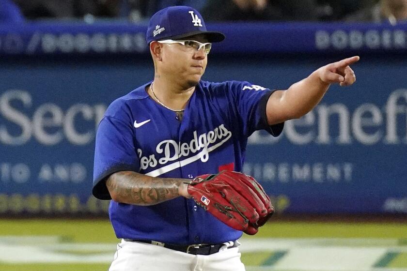 Los Angeles Dodgers starting pitcher Julio Urias gestures toward shortstop Miguel Rojas.