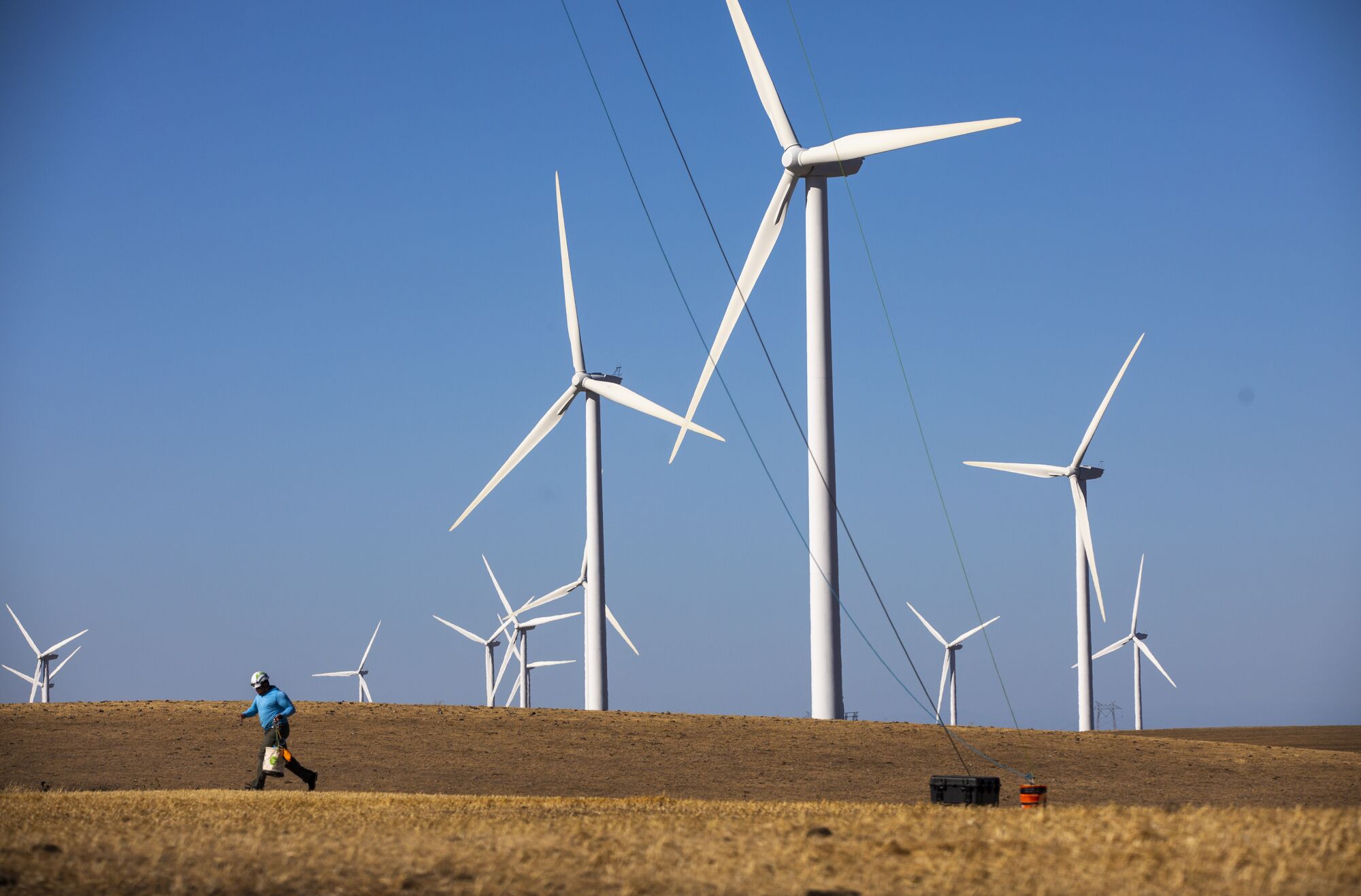 A person runs among wind turbines.