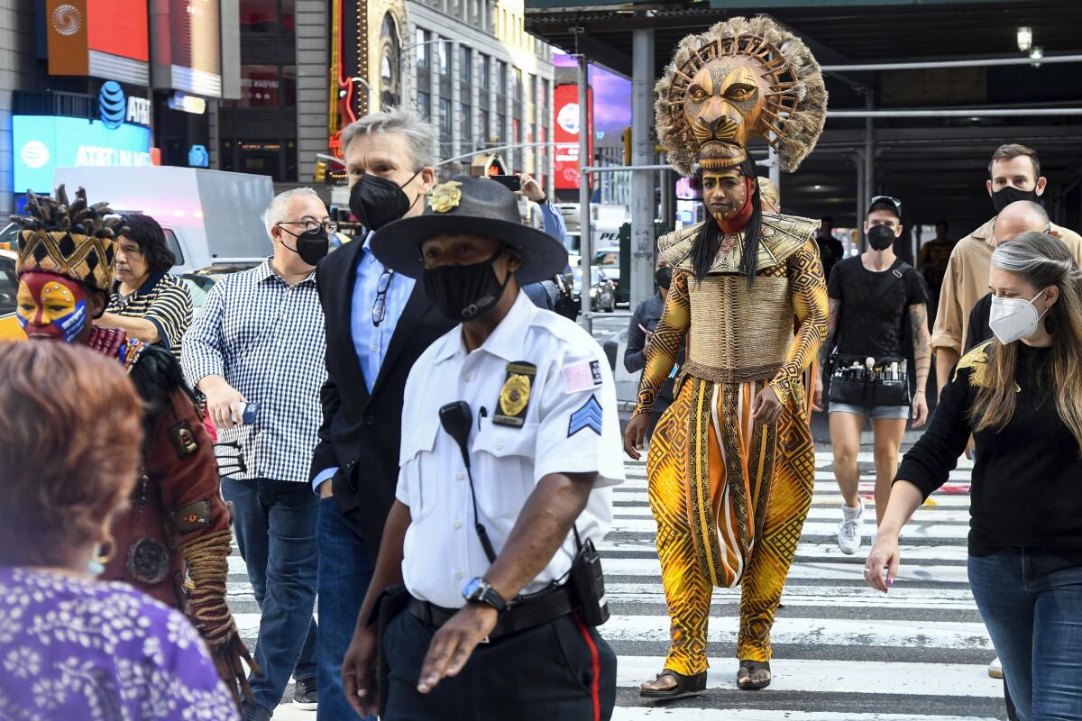 Costumed cast members of Broadway's "The Lion King," L. Steven Taylor, as Mufasa, right, and and Tshidi Manye, as Rafiki, left, appear in Times Square to herald the return of Broadway theater in New York, Tuesday, Sept. 14, 2021. (Marc A. Hermann / Metropolitan Transportation Authority via AP)